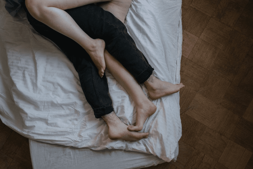 couple's legs on bed

